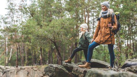 Mutter und Tochter wandern gemeinsam im Herbstwald